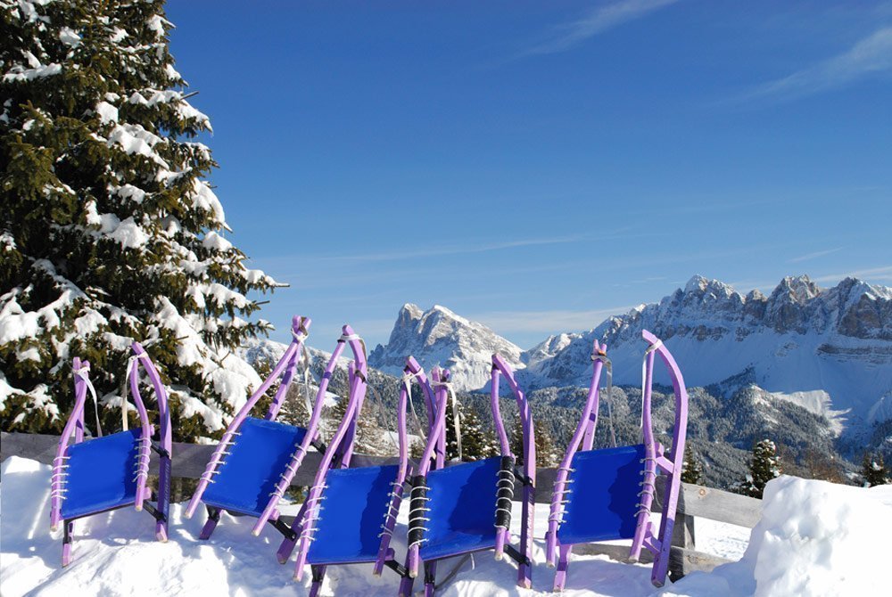 Rodelspaß vor Traumkulisse im Skiurlaub mit Familie